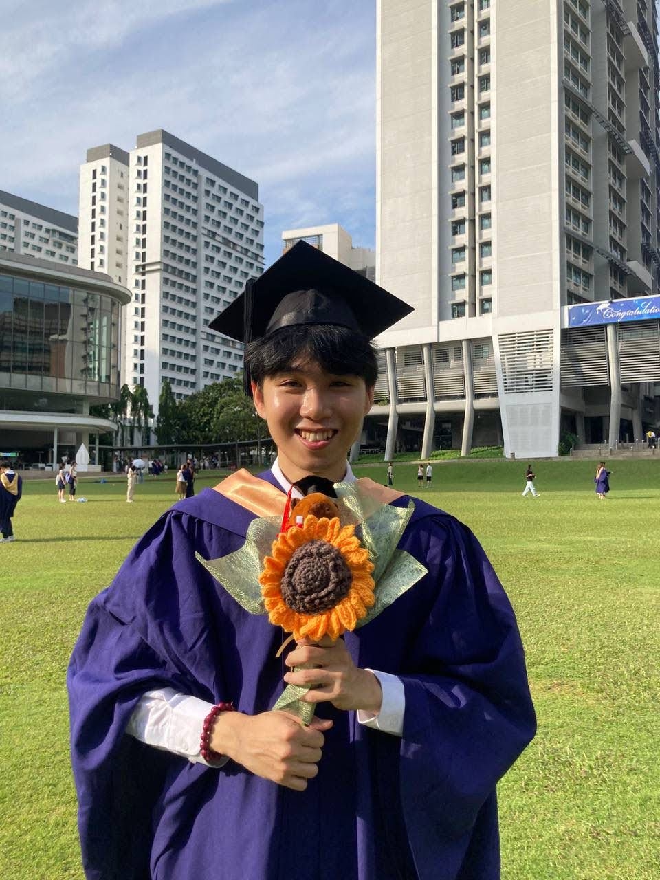 Lee Chee Tong, 24, graduated from NUS Social Work this year. He is holding a flower in his graduation gown.